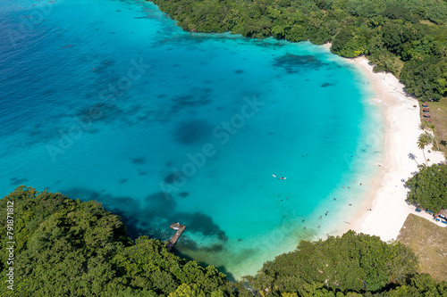 Drone view of sandy beach and green shore near turquoise sea. Tourist settlement. Sanma, Vanuatu..