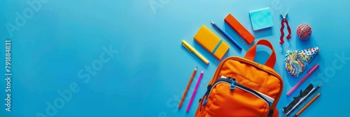 A flat lay photography featuring a backpack filled with school supplies, set against a blue background