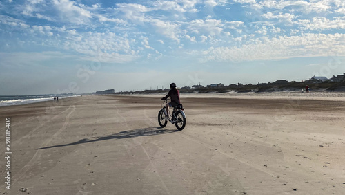 Quadro em tela Woman biking on Fernandina Beach on a Sunny Day in Amelia Island Florida