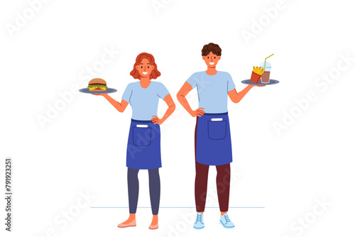 Waiters from fast food restaurant work together to deliver customers order, holding burgers and fries on trays. Man and woman working as waiters in cafe, enjoying jobs in hospitality industry