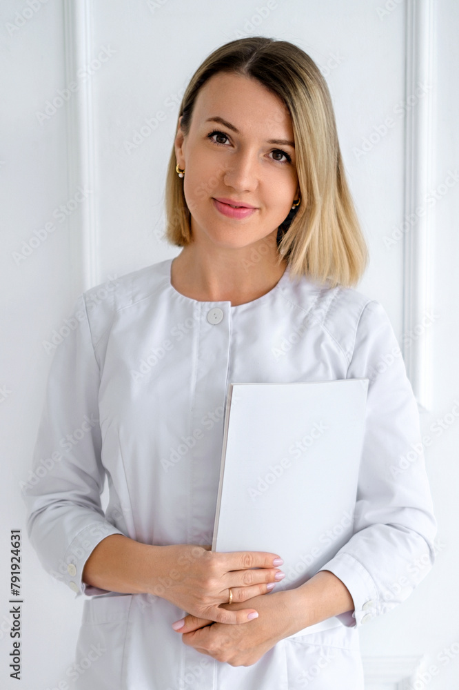 A female doctor in a white coat with a patient's medical record. A female doctor in a white coat with a patient's medical record.