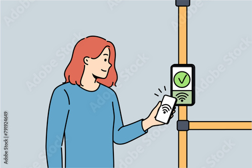 Woman uses bus terminal to accept contactless payments by touching phone to NFC sensor. Smiling girl rejoices at presence of NFC technology for payment via smartphone in public transport