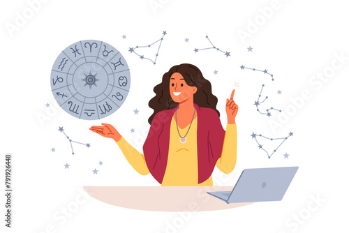 Woman astrologer tells fortunes by horoscope and predicts future by stars, standing near table with laptop. Girl astrologer points up, offering to read gorsk, standing near wheel with zodiac signs