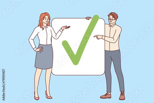 Business partners have completed project show check mark proving completion of assigned tasks. Man and woman office employees striving together to achieve commercial goals and complete project