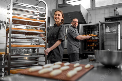 Man and woman working in a bakery and looking contented photo