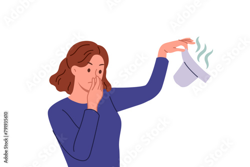 Woman with smelly baby diaper in hand covers nose, feeling disgusting smell caring for child. Unhappy mother changes son or daughter diaper, feeling disgusted and tired of motherhood