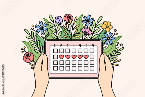 Menstrual cycle calendar in hands of woman and flowers, for design of gynecological products for girl or calculation of PMS. Women health concept and tracking menstrual or PMS days