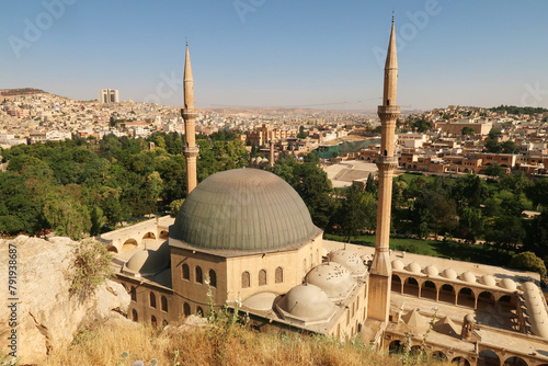 View onto the Dergah Complex housing the Mevlidi Halil Camii Mosque and Abrahams Birth Cave and the city of Sanliurfa in the background, Sanliurfa, Turkey photo