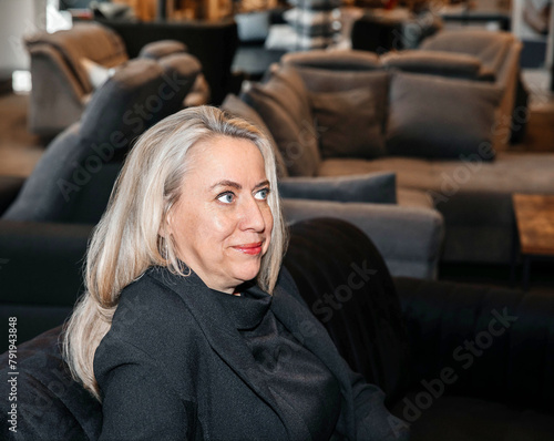 Confident Silver-Haired Woman in Black Outfit at a Modern Showroom