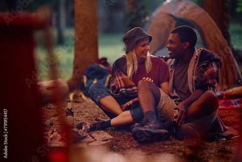 Young happy couple talking while enjoying on camping in nature.