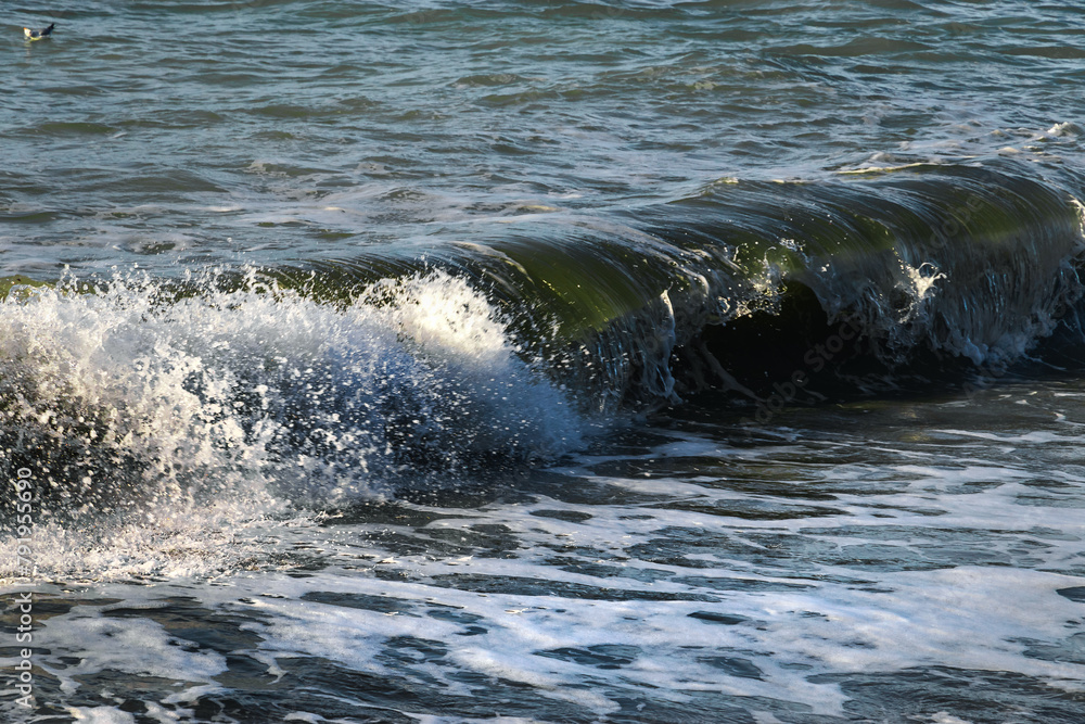 Clear wavy sea water. Splashes of waves break on the rocks. Sea surf on the beach. The power of water on the sea surf. Splashes of sea waves. Clear wavy sea water. Splashes of waves break on the rocks. Sea surf on the beach. The power of water on the sea surf. Splashes of sea waves.