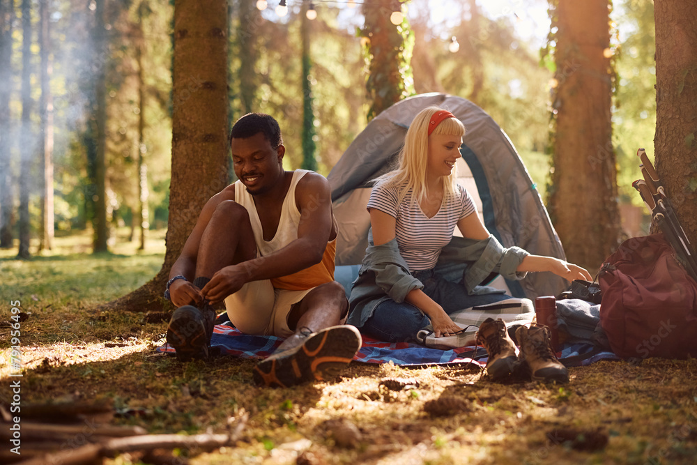 Young multiracial couple enjoying in camping in forest. Young multiracial couple enjoying in camping in forest.