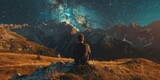 A man is sitting on a hillside, looking up at the stars. The scene is peaceful and serene, with the man taking a moment to appreciate the beauty of the night sky