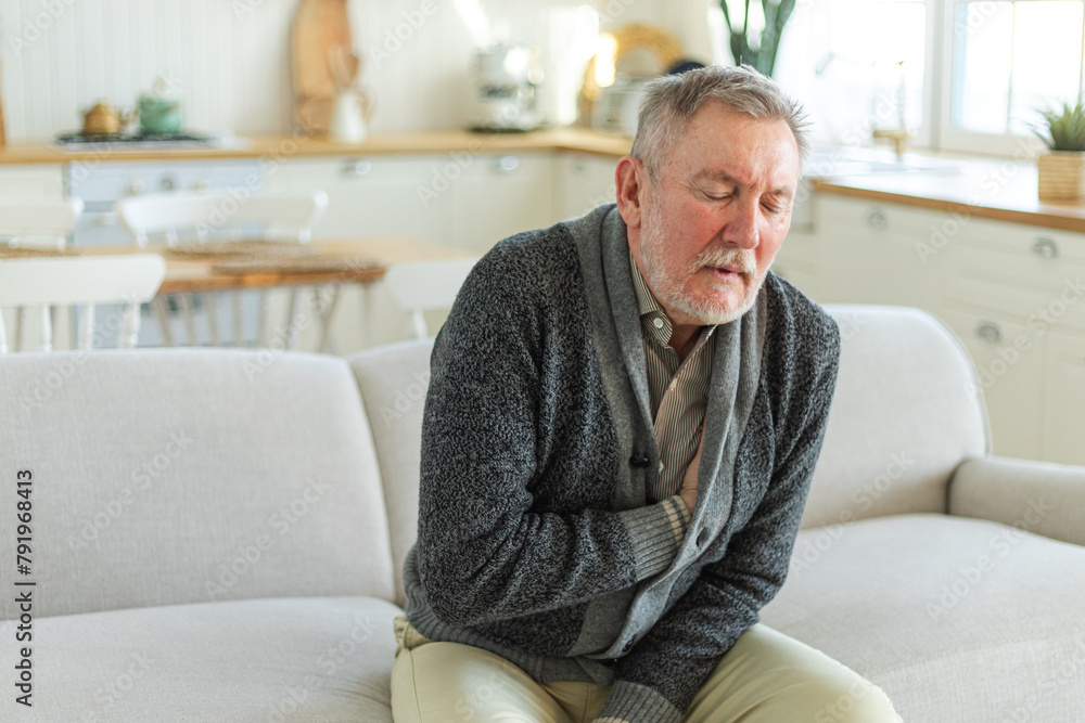 Pain on heart, heart attack. Unhappy middle aged senior man suffering from chest pain heart attack problems with health at home. Mature old senior grandfather touching chest experiencing infarction Pain on heart, heart attack. Unhappy middle aged senior man suffering from chest pain heart attack problems with health at home. Mature old senior grandfather touching chest experiencing infarction