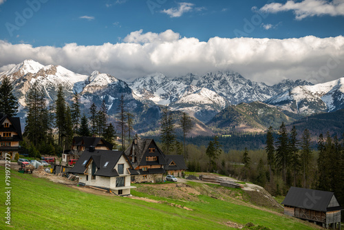 Wiosenna panorama na Tatry Wysokie z góralskimi domami w widokowym miejscu na pierwszym planie