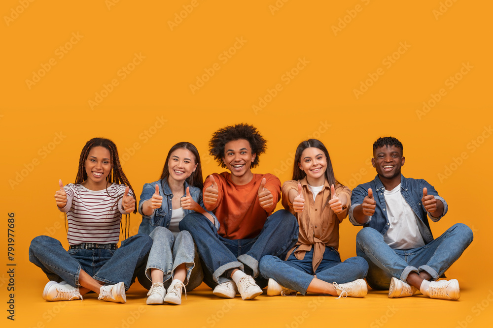 Obraz premium Young friends showing thumbs up in casual wear