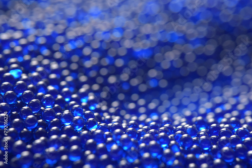 Abstract background in soft selective focus of the blue spherical shape water gel balls, beads or blasters