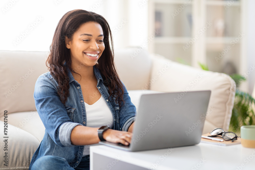 Woman Entrepreneur Sitting on Couch Using Laptop Computer Woman Entrepreneur Sitting on Couch Using Laptop Computer