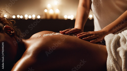 African-american woman enjoying salt scrub massage at spa