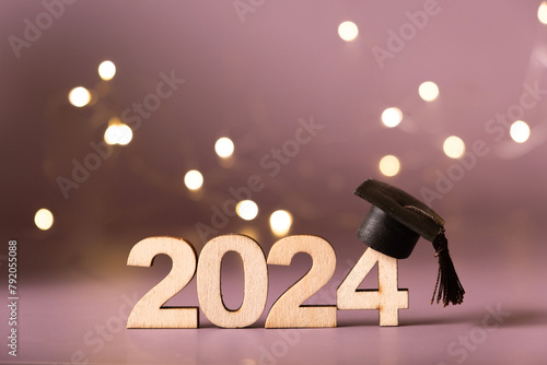 Number 2024 with graduated cap and bokeh lights. Class of 2024 concept © Alina