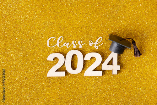 Class of 2024 text. Golden glitter background with number 2024 and graduated cap © Alina