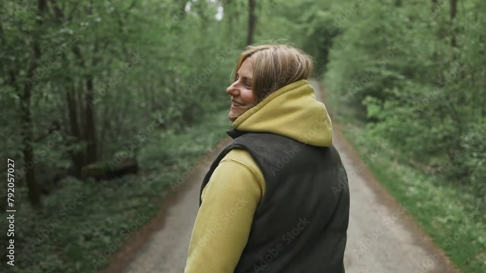 Portrait of cheerful happy lady walks by trail in spring, enjoying time in forest. Female hiker relax in nature for mental health, wellness and breathing, forest trees and fresh air. Portrait of cheerful happy lady walks by trail in spring, enjoying time in forest. Female hiker relax in nature for mental health, wellness and breathing, forest trees and fresh air.