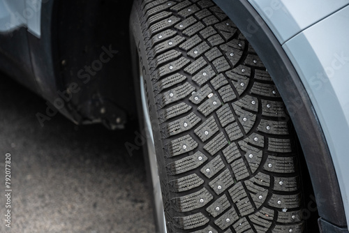 Studded winter tires on a wgite car.