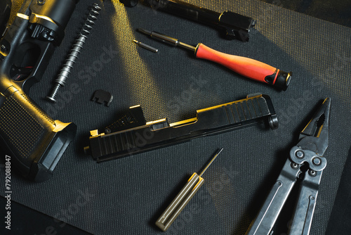 Gunsmithing, cleaning and repairing weapons. Disassembled pistol in a workshop. photo