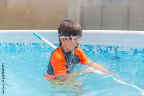 Boy in pool with swim noodle, working on swimming skills on a bright summer day