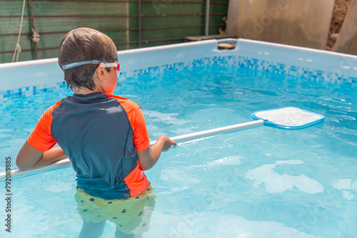 Boy standing in pool with swim noodle, preparing for swimming on a warm sunny day