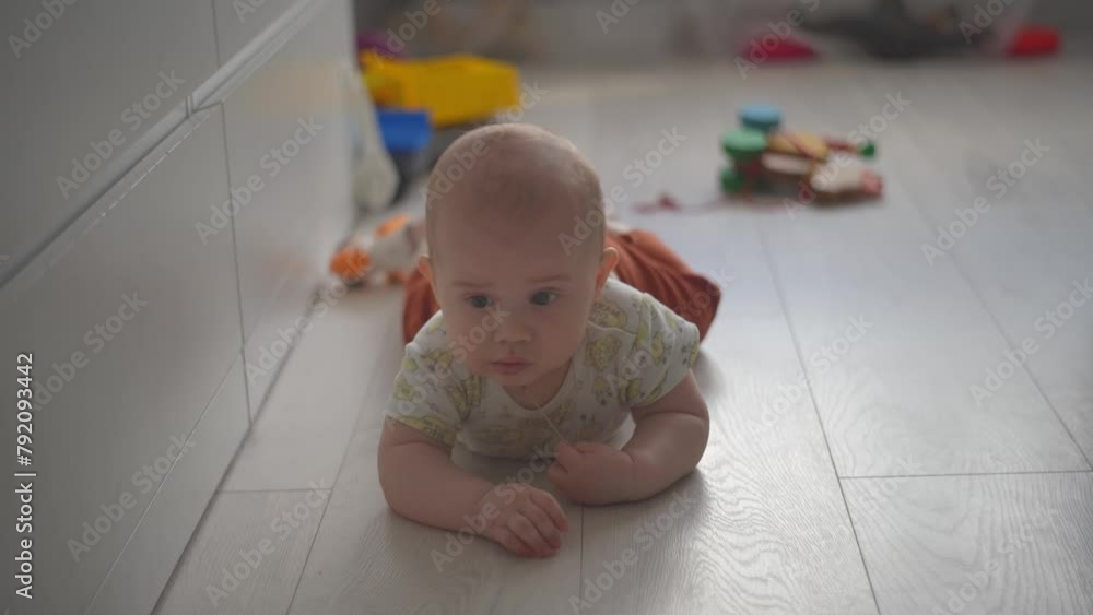 Baby exploring all around the house, 7 month old baby boy crawling, touching everything. Baby learning to crawl and play on the floor with a toys.