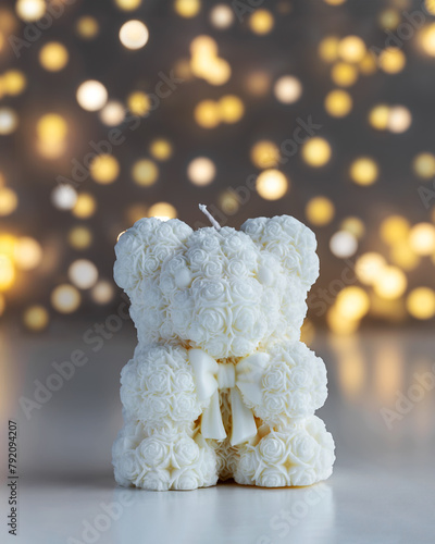 Handmade candle in the shape of teddy-bear with with lights in background. Holiday gift. Soy wax candles