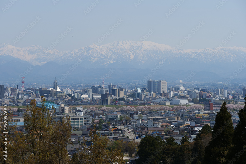 Obraz premium 満開の桜春霞の薬師岳北アルプス立山連峰と神通大橋と富山市街地