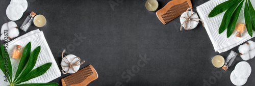 Wellness and spa accessories on dark concrete background. Towel, hairbrush, candles and soap.