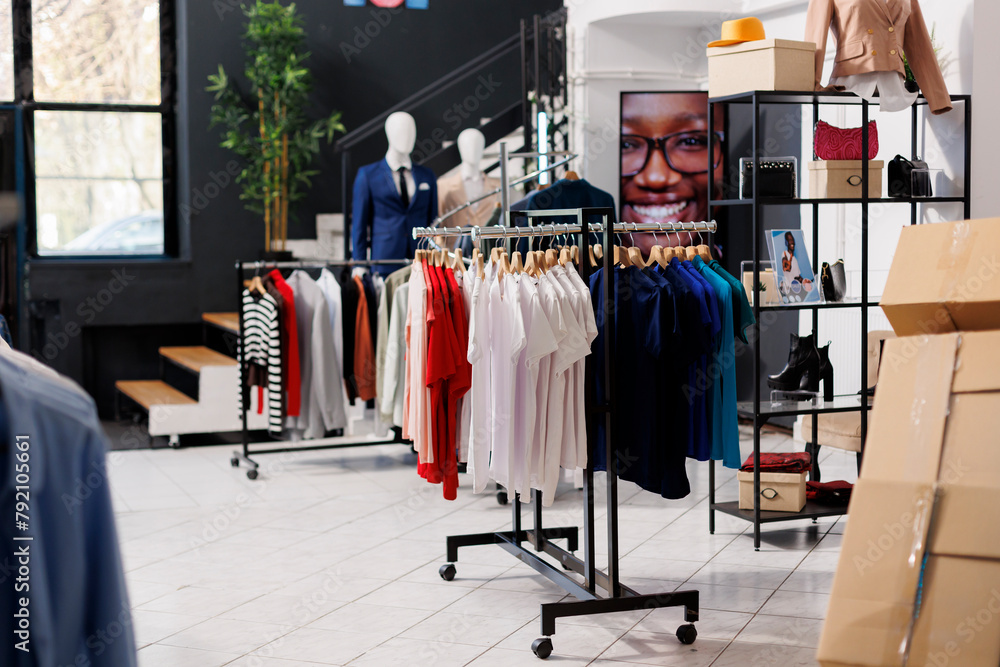 Empty fashion store with casual and formal wear design, retail shop with stylish clothes on hangers and racks. Modern boutique inside of shopping mall, fashionable merchandise on sale. Empty fashion store with casual and formal wear design, retail shop with stylish clothes on hangers and racks. Modern boutique inside of shopping mall, fashionable merchandise on sale.