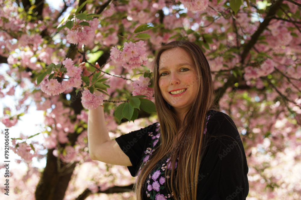 Portrait of a Woman Surrounded by Ornamental Cherry Blossoms and Lush Foliage Portrait of a Woman Surrounded by Ornamental Cherry Blossoms and Lush Foliage
