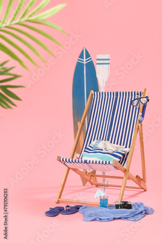 Deckchair  beach accessories and glass of cocktail on pink background