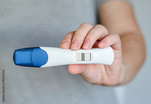 Close up of a woman holding a digital positive pregnancy test