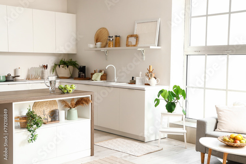 Interior of modern kitchen with white furniture and island table © Pixel-Shot