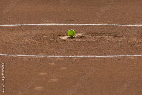 Women's or girl's softball on the pitcher's mound of a softball field.