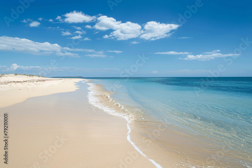 Sandy beach stretching as far as the eye can see  bordered by azure waters