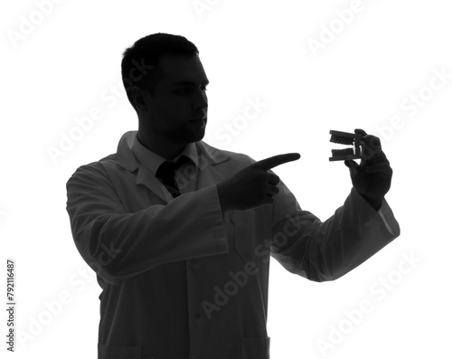 Silhouette of male dentist pointing at jaw model on white background