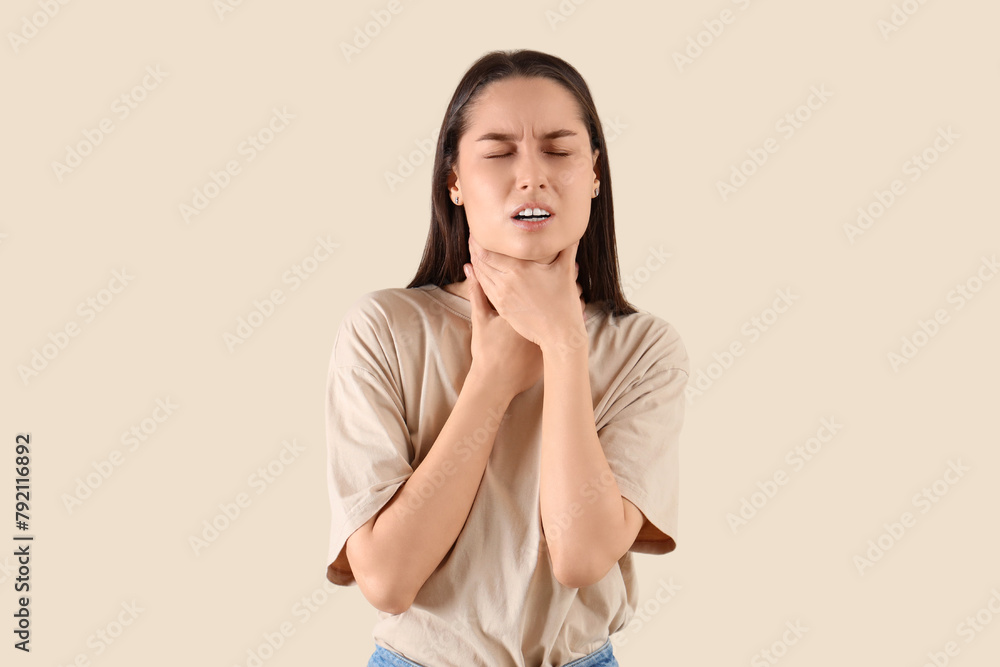 Young woman suffering from sore throat on beige background Young woman suffering from sore throat on beige background