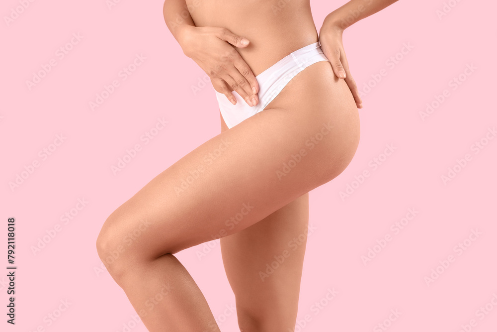 Beautiful young African-American woman with stretch marks on her body against pink background, closeup