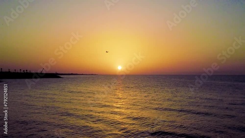 Aereo da turismo che vola al tramonto sopra al sole con mare calmo e con il  promontorio del Gargano sullo sfondo  photo