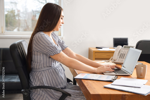 Pregnant businesswoman work...