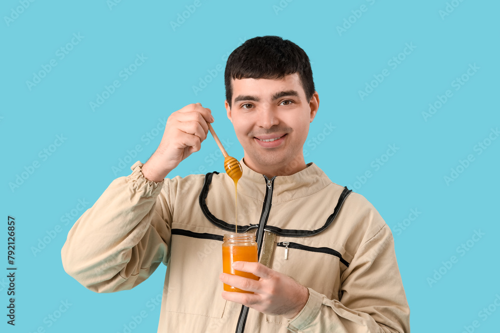 Male beekeeper with honey and spoon on blue background, closeup Male beekeeper with honey and spoon on blue background, closeup