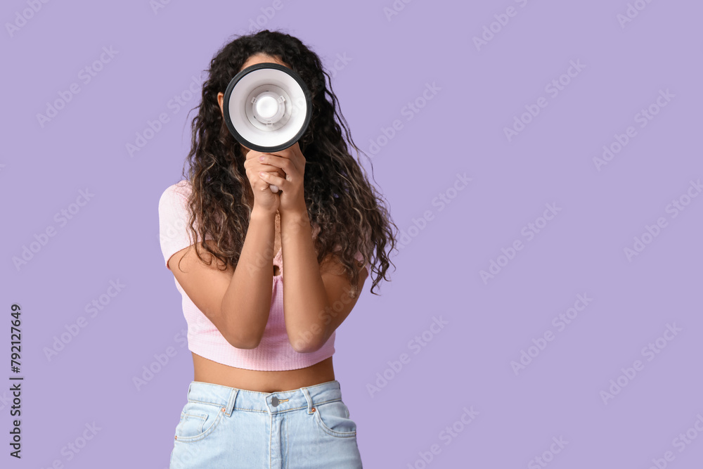 Fototapeta premium Young African-American woman with megaphone on lilac background
