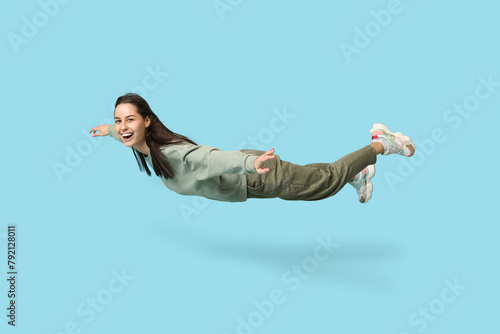 Joyful young woman flying o...