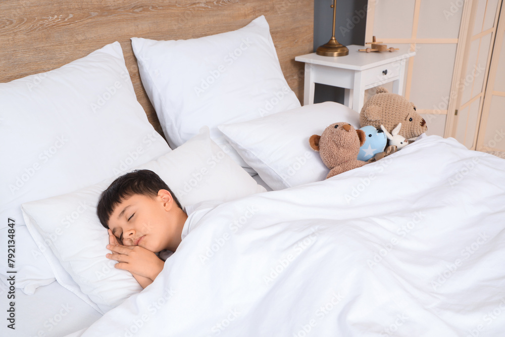 Cute little boy with toys sleeping in bedroom Cute little boy with toys sleeping in bedroom
